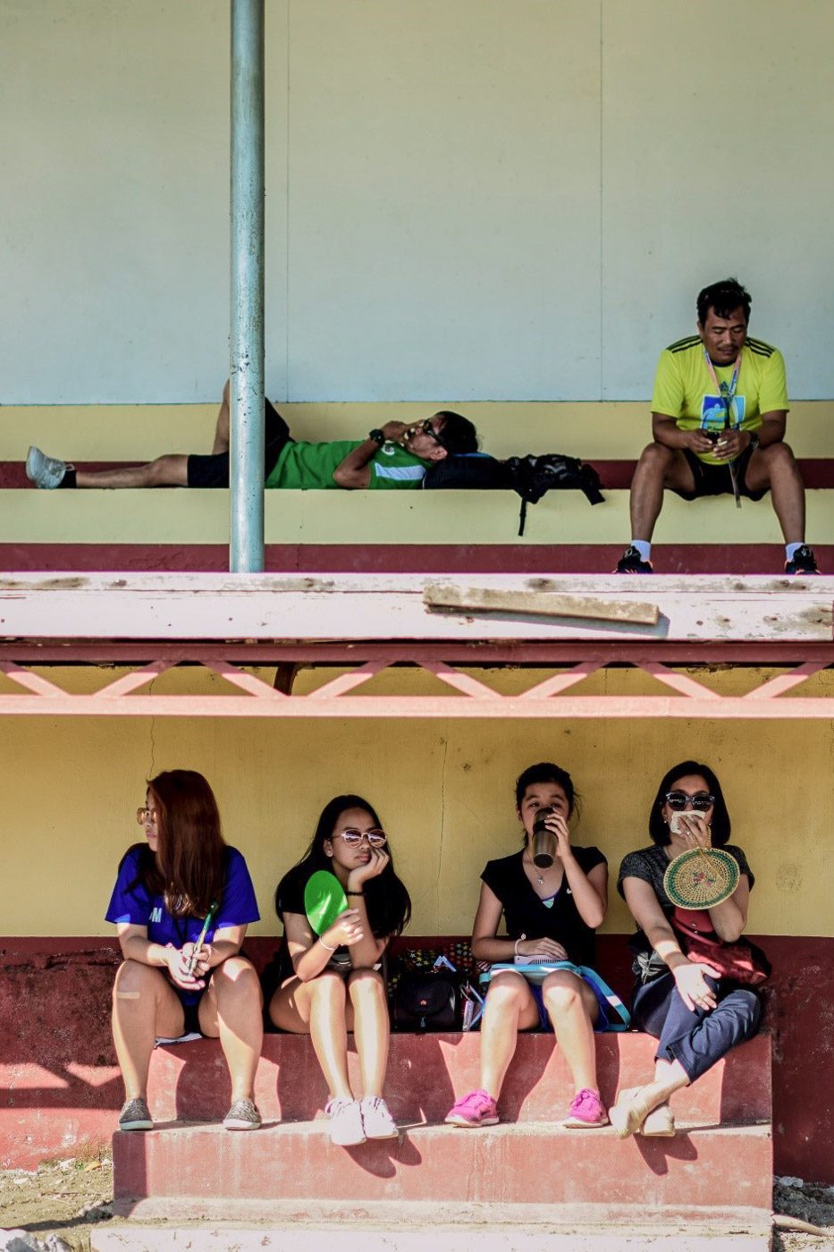 BEAT THE HEAT. Audience members during a football match between National Capital Region (NCR) and Northern Mindanao shade themselves from intense sunlight. Photo by Bea Mae Punongbayan/Rappler   