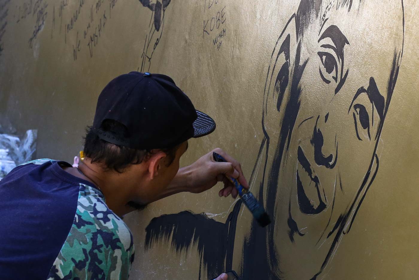 CREATIVE. A man paints his own mural of Kobe Bryant on the wall of the House of Kobe. Photo by Jire Carreon/Rappler 