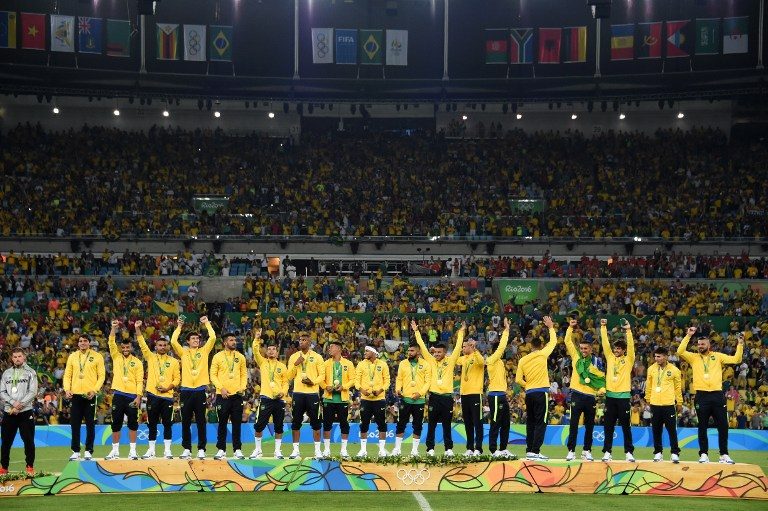 CHAMPS. Brazil's forward Neymar (C) and teammates celebrate on the podium during the medal presentation following the Rio 2016 Olympic Games men's football gold medal match between Brazil and Germany at the Maracana stadium in Rio de Janeiro on August 20, 2016. Vanderlei Almeida/AFP 
