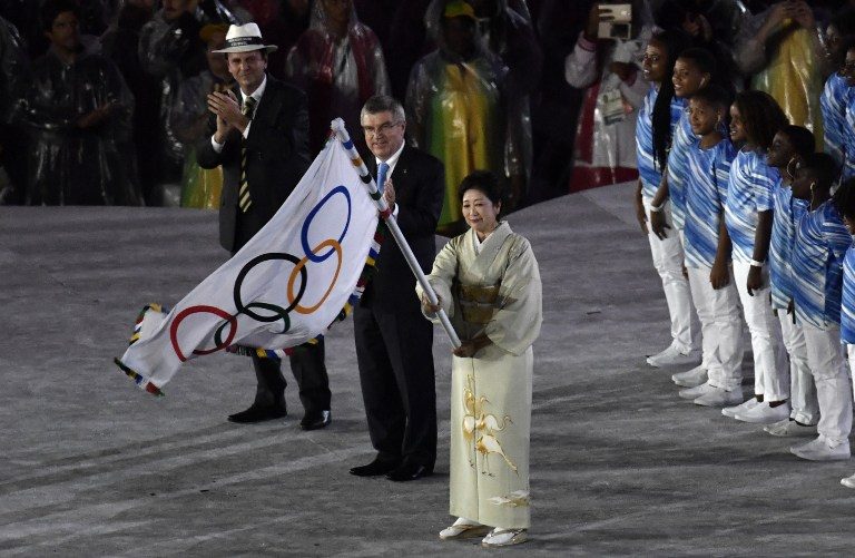 TURNOVER. The Governor of Tokyo Yuriko Koike (R) waves the Olympic flag next to the International Olympic Committee (IOC) President Thomas Bach (C) and the Mayor of Rio Eduardo Paes during the closing ceremony of the Rio 2016 Olympic Games at the Maracana stadium in Rio de Janeiro on August 21, 2016. Philippe Lopez/AFP 