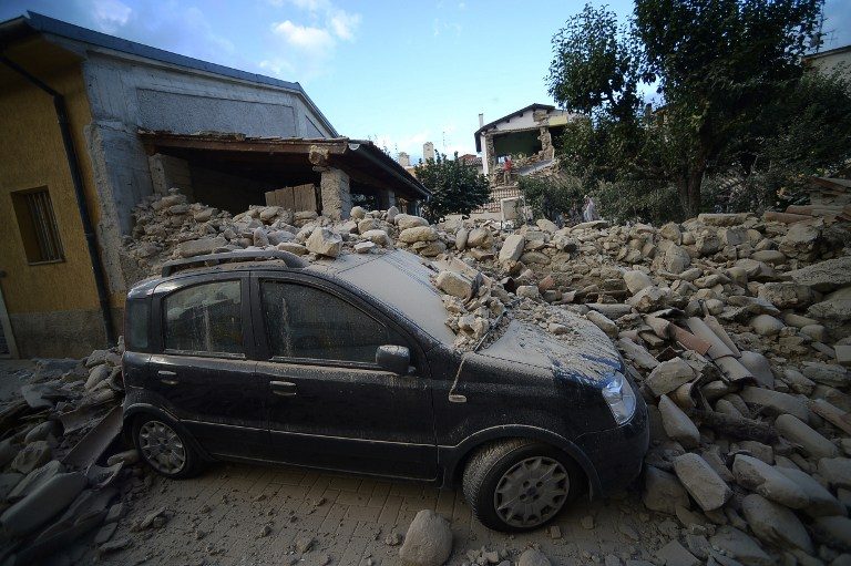 RUBBLE. A car lies under a damaged wall after a strong earthquake hit Amatrice on August 24, 2016. Filippo Monteforte/AFP  