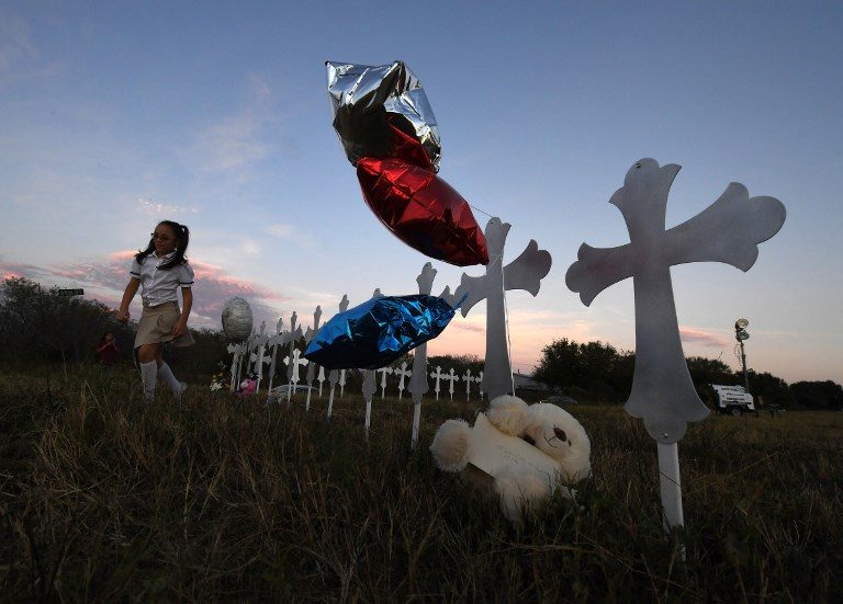GRIEF. Heather Cooper, 8, leaves after placing her favorite doll on a row of crosses for each victim, after a mass shooting that killed 26 people in Sutherland Springs, Texas on November 6, 2017. Photo by Mark Ralston/AFP 