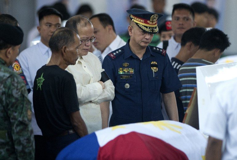 GRIEF. President Benigno Aquino III (center) pays his respects before one of 44 police commandos killed in a botched anti-terror operation, during a necrological service at Camp Bagong Diwa on January 30, 2015. Photo by Noel Celis/AFP     