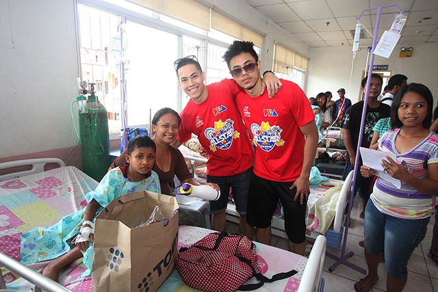 LA Revilla and Terrence Romeo photo op with a child patient at Ospital ng Palawan. Photo by Nuki Sabio/PBA Images 