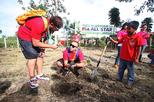 Beau Belga does an interview for TV5 on Paul Lee while planting a tree. Photo by Nuki Sabio/PBA Images 
