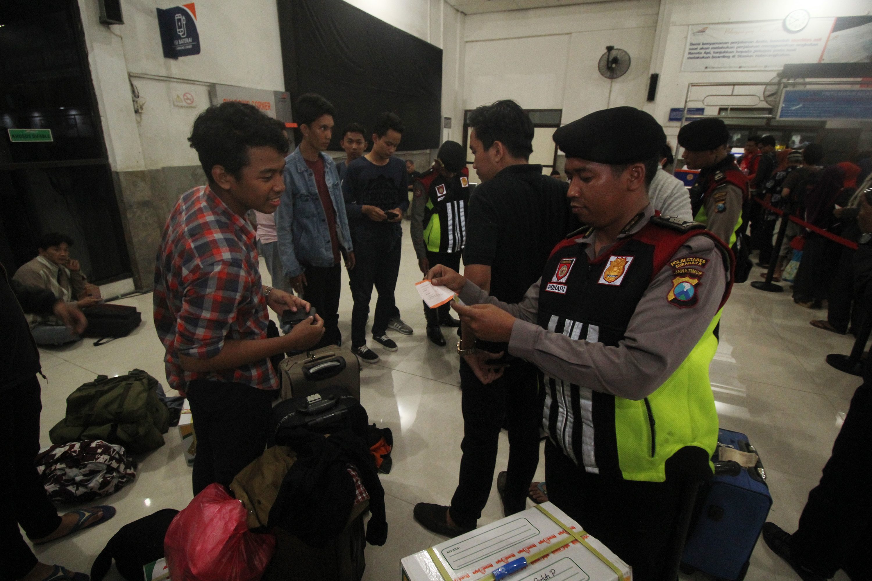 Sejumlah anggota polisi patroli motor (patmor) Sat Sabhara Polrestabes Surabaya memeriksa identitas para calon penumpang kereta api jurusan Surabaya-Jakarta di Stasiun Pasar Turi, Surabaya, Jawa Timur, pada 18 April 2017. Foto oleh Moch Asim/Antara 