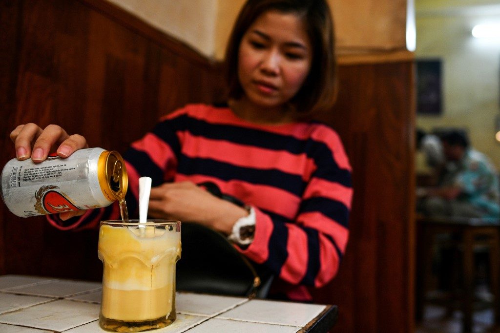 TASTE. Malaysian tourist ST Lim drinking egg beer at the Giang Cafe in Hanoi.  Photo by Manan Vatsyayana / AFP  