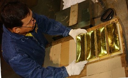 BIG GOLD BUYER. Bangko Sentral ng Pilipinas (BSP) sources gold from small scale miners. This file photo shows a BSP worker stacking newly minted gold bar at the central bank's gold refinery plant. Photo by AFP