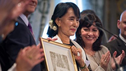 Myanmar pro-democracy leader Aung San Suu Kyi (C) poses after receiving an honorary citizen award, beside Paris' deputy mayor Anne Hidalgo (R) at the Paris City Hall on June 27, 2012. AFP PHOTO / FRED DUFOUR