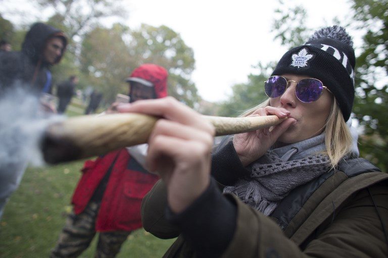 WEED PARTY. A woman smokes a marijuana cigarette during a legalization party at Trinity Bellwoods Park in Toronto, Ontario, October 17, 2018.  Photo by Geoff Robins/AFP  