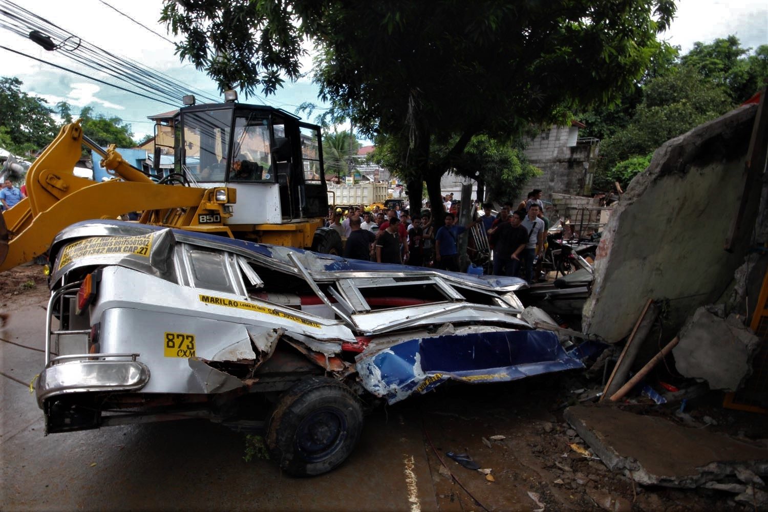 FLATTENED. A jeepney is flattened following the collapse and explosion of a water tank. Photo by DARREN LANGIT 