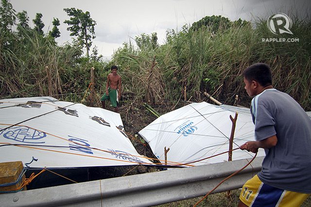 TEMPORARY SHELTER. Matias Balbada from Marabut town builds a tent along the provincial highway. Photo by Vincent Go