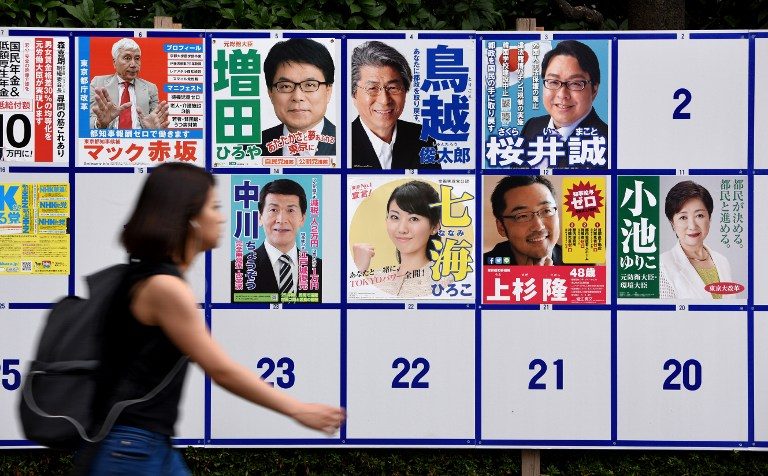 CANDIDATES. A woman walks past campaign posters of candidates for Tokyo governor in Japan on July 28, 2016. File photo by Toru Yamanaka/AFP 