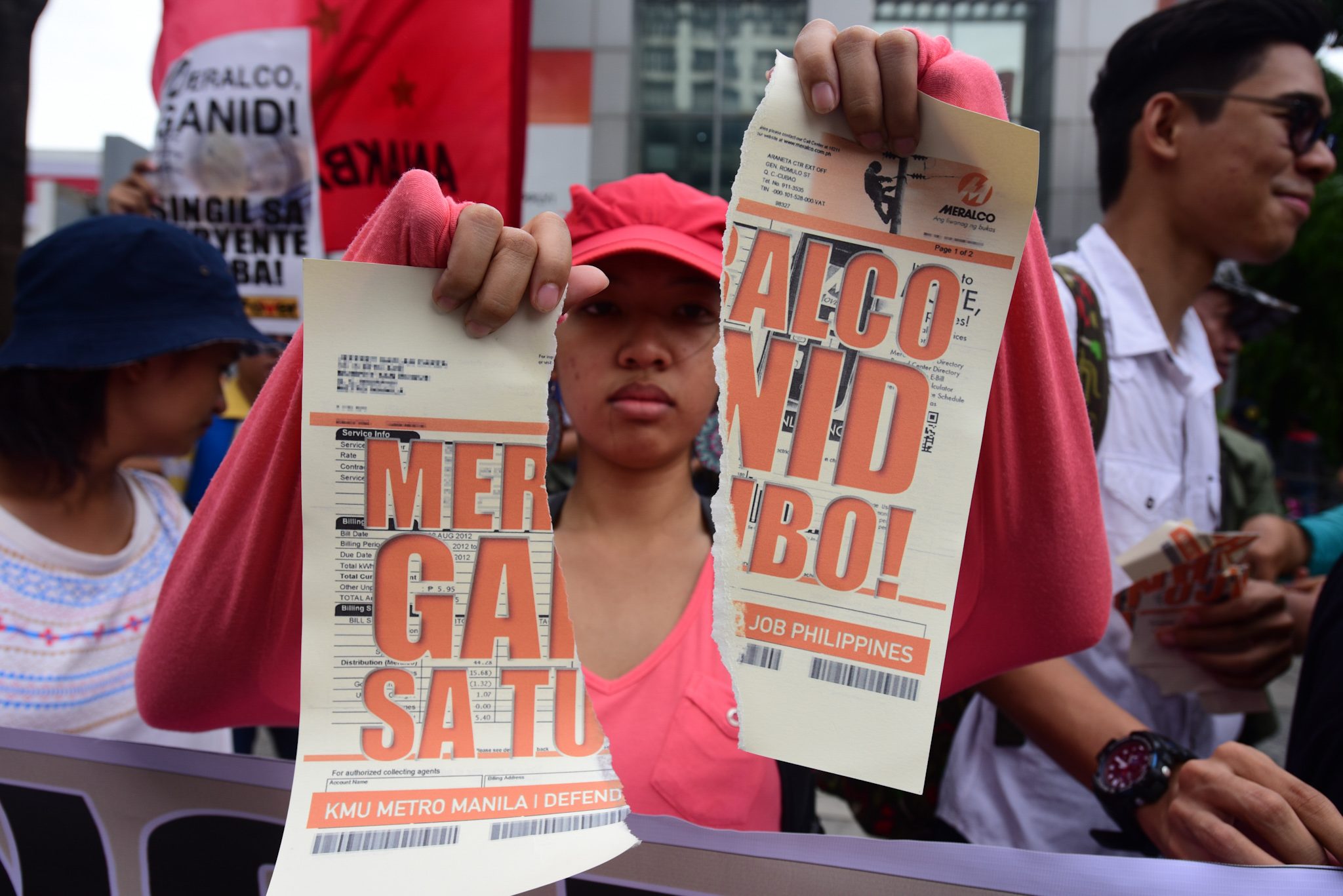 BLACK FRIDAY PROTEST. An activist tears apart a mock electricity bill on June 8, 2018, in Manila, to protest an impending power rate hike. Photo by Maria Tan/Rappler   