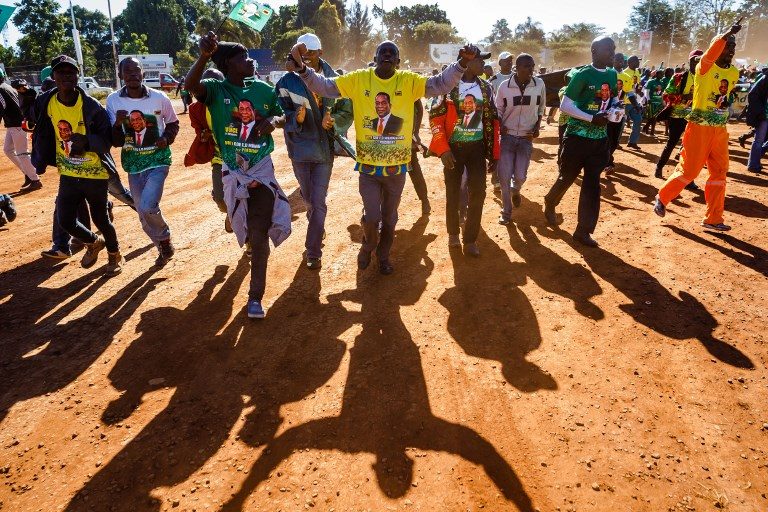 PEACE MARCH. Activists from Zimbabwe's ruling party Zimbabwe African National Union Patriotic Front (ZANU PF) Youth League cheer as they march for peace on June 6, 2018, in Harare, ahead of the July 30 general elections. Photo by Jekesai Njikizana/AFP   