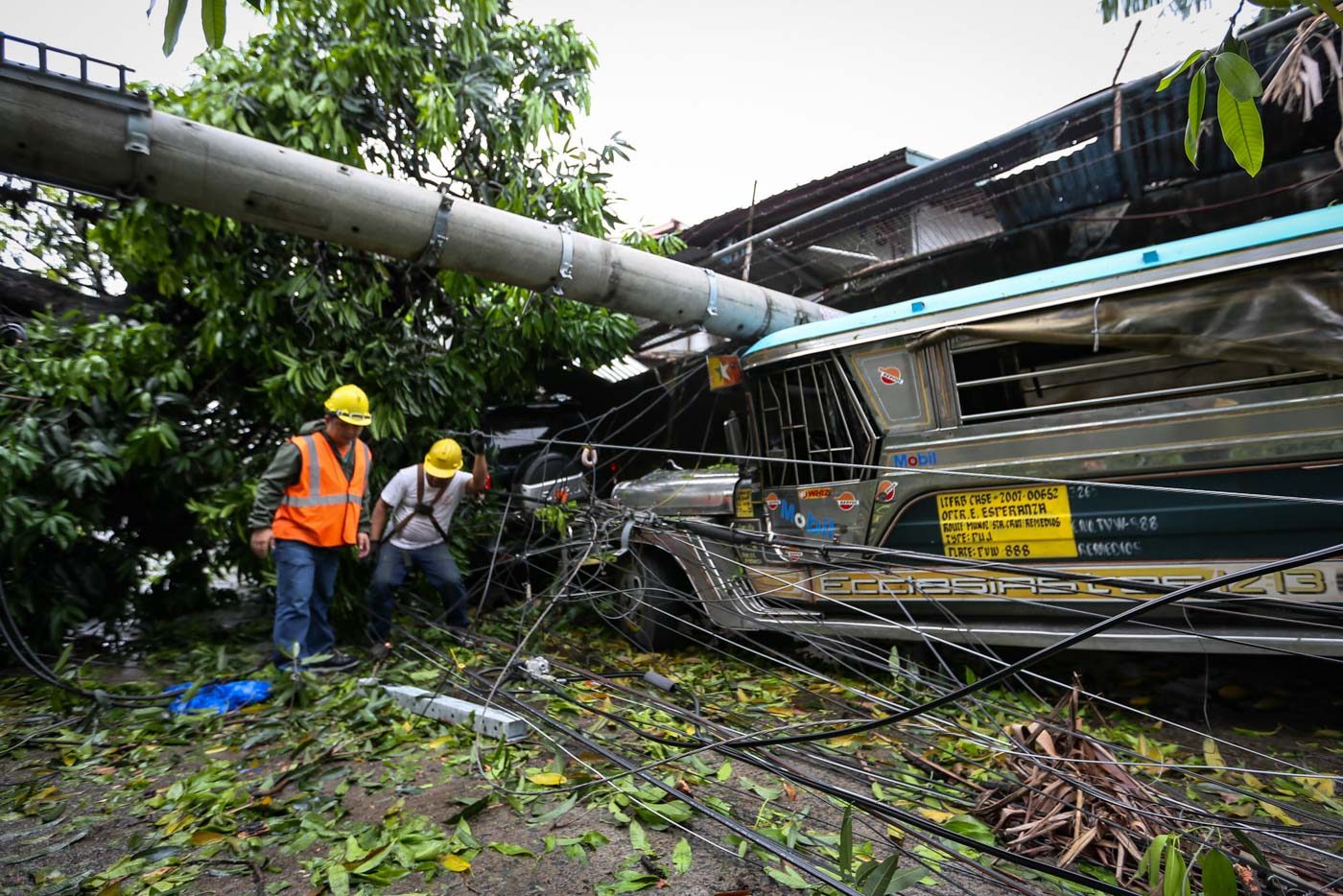 POWER OUT. An electric post hits a parked jeepney in West Riverside, San Francisco del Monte in Quezon City, after being toppled by strong winds. Photo by Maria Tan/Rappler   