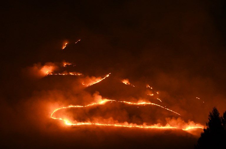 HEAT WAVE. Flames and smoke rising from a forest in fire near Sarande in the Muzina mountain region, southern Albania. Photo by Gent Shkullaku/AFP   