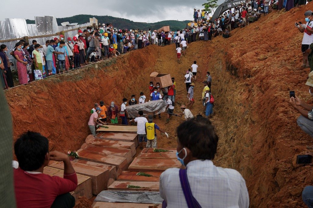 MASS BURIAL. Volunteers bury bodies of miners in a mass grave while relatives look on during a funeral ceremony near Hpakant in Kachin state on July 3, 2020. Photo by Zaw Moe Htet/AFP 
