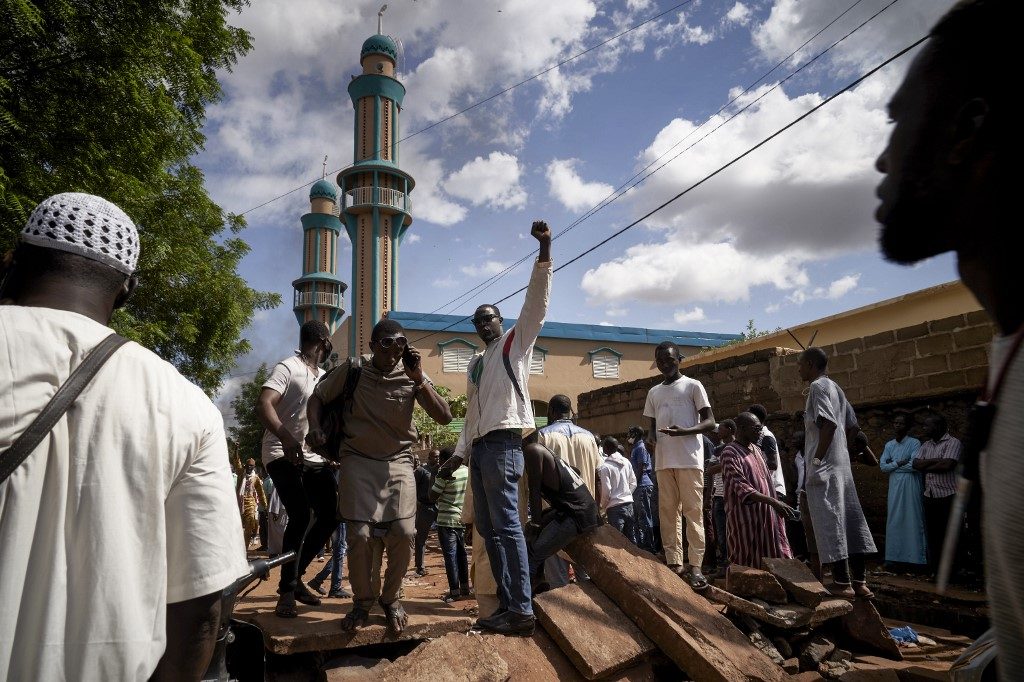CLASHES. In this file photo, protesters gestures on a barricade put up in front of the Salam mosque of Badalabougou, where the influent Imam Mahmoud Dicko led a prayer dedicated to the victims of the clashes of the past two days in Bamako on July 12, 2020. File photo by Michele Cattani/AFP 
