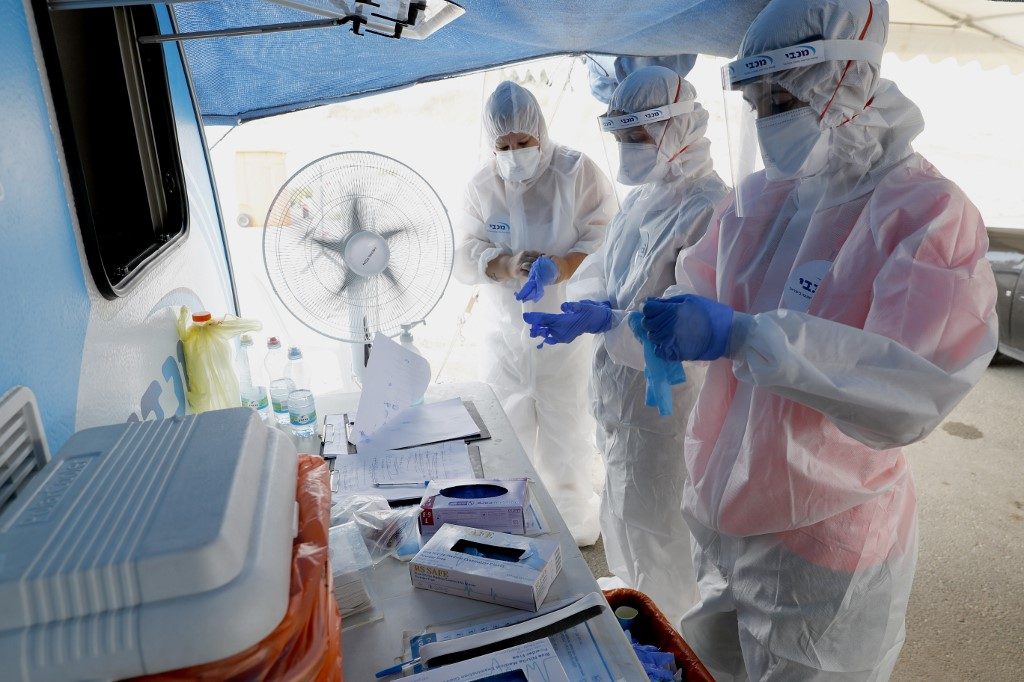 CORONAVIRUS MEASURES. Israeli medical personnel take samples at a drive through COVID-19 testing facility in Ramat Hasharon in the suburbs of Tel Aviv, on July 6, 2020 during measures imposed by the Israeli authorities to curb the spread of the novel coronavirus. Photo by Jack Guez/AFP 