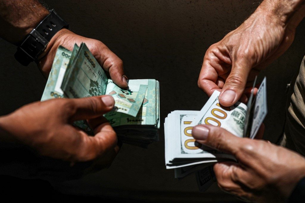 BLACK MARKET. People exchange Lebanese pound and US dollar notes on the black market in Lebanon's capital Beirut on June 18, 2020. Photo by Joseph Eid/AFP 
