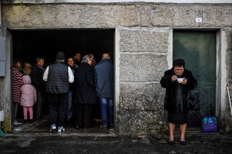MEAL FEAST. A woman eats soup as others wait for theirs during the annual 'Table of Saint Sebastian communal meal feast' in honor of Saint Sebastian at Vila Grande, Portugal, on January 20, 2019, as gratitude for the protection of Saint Sebastian against the French invasion and the plague. Photo by Patricia de Melo Moreira/AFP  