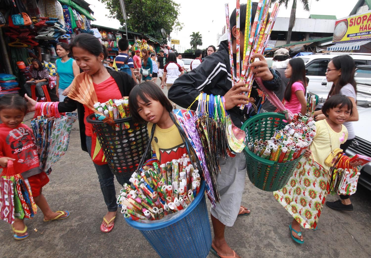 ENTERPRISING. Children sell Christmas wrappers at the Commonwealth Market in Quezon City. Photo by Joel Liporada/Rappler  