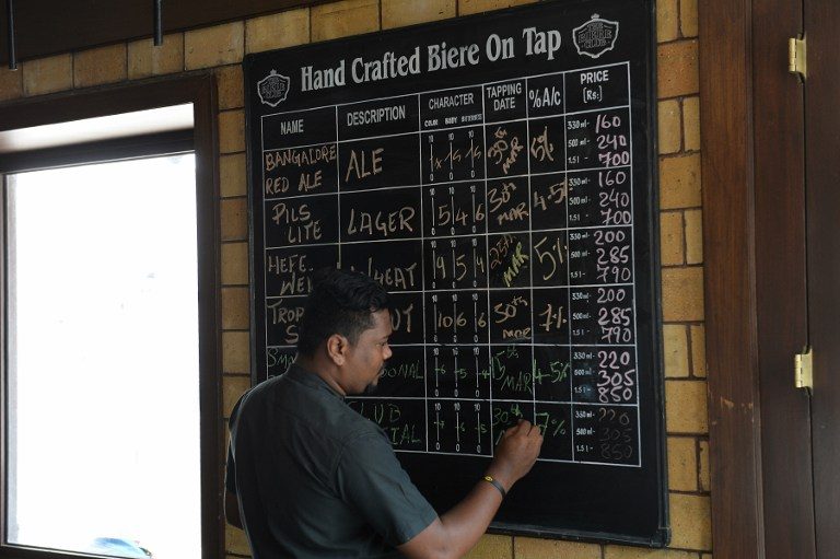 FROM ALE TO LAGER. A staff member writes descriptions of the craft beer made at The Biere Club's microbrewery in Bangalore, March 31, 2016. Photo by Manjunath Kiran/AFP 