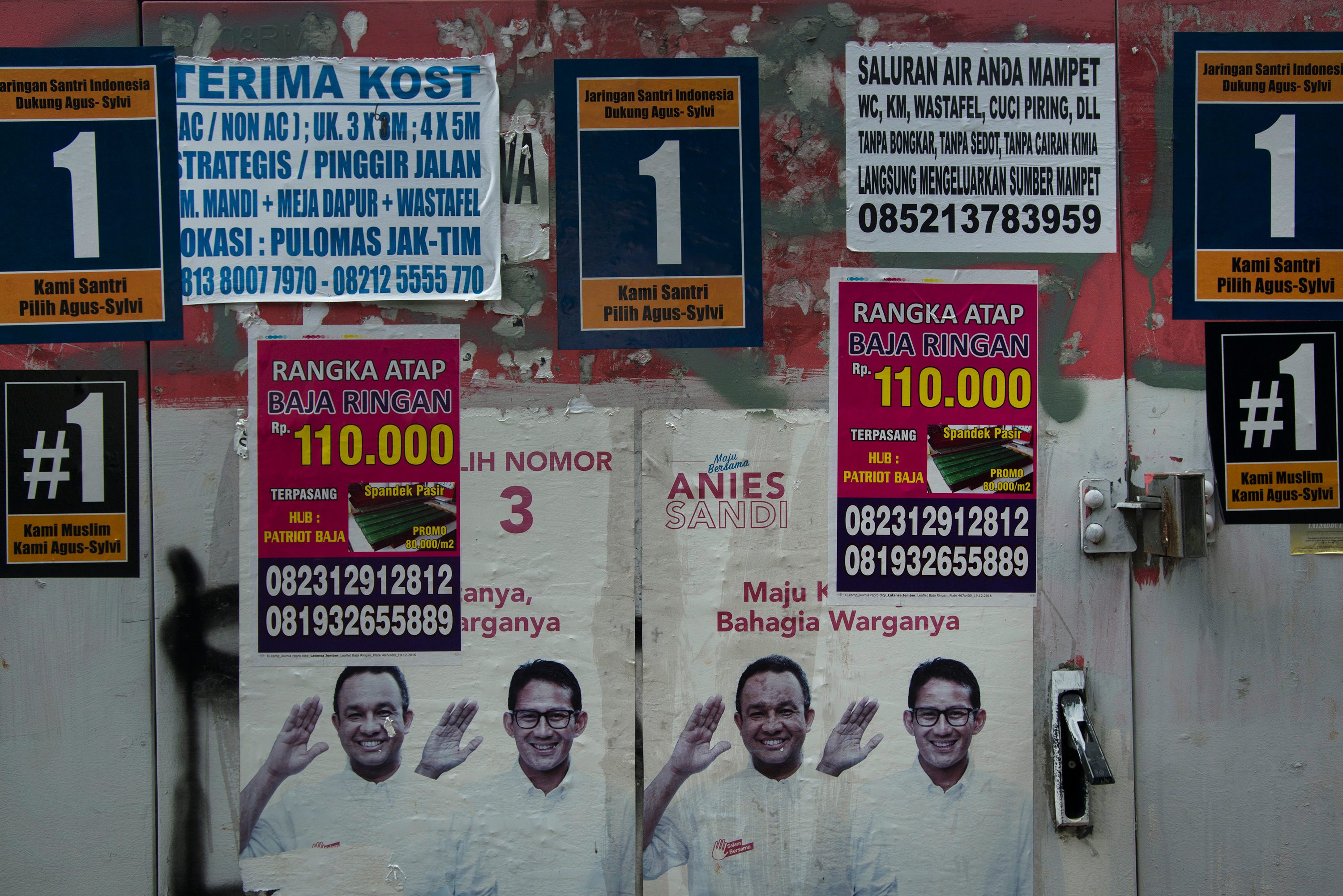Sejumlah atribut kampanye cagub dan cawagub DKI Jakarta masih terpasang di ruang publik pada hari pertama minggu tenang kampanye, pada 12 Februari 2017. Foto oleh Rosa Panggabean/Antara 