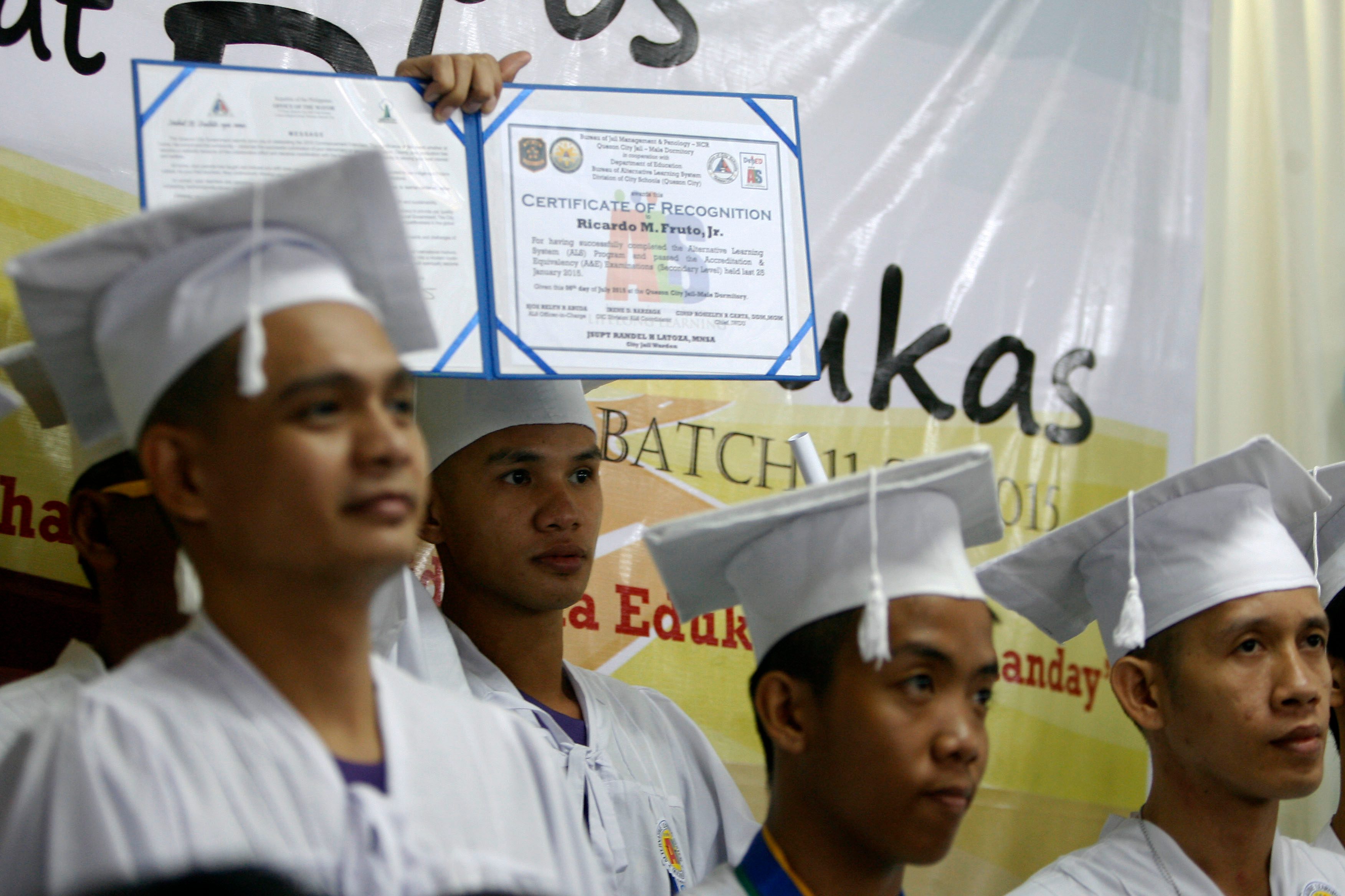 A detainee proudly shows his certificate of recognition during their graduation at the Alternative Learning System (ALS) program of the Department of Education inside the Quezon City Jail. 