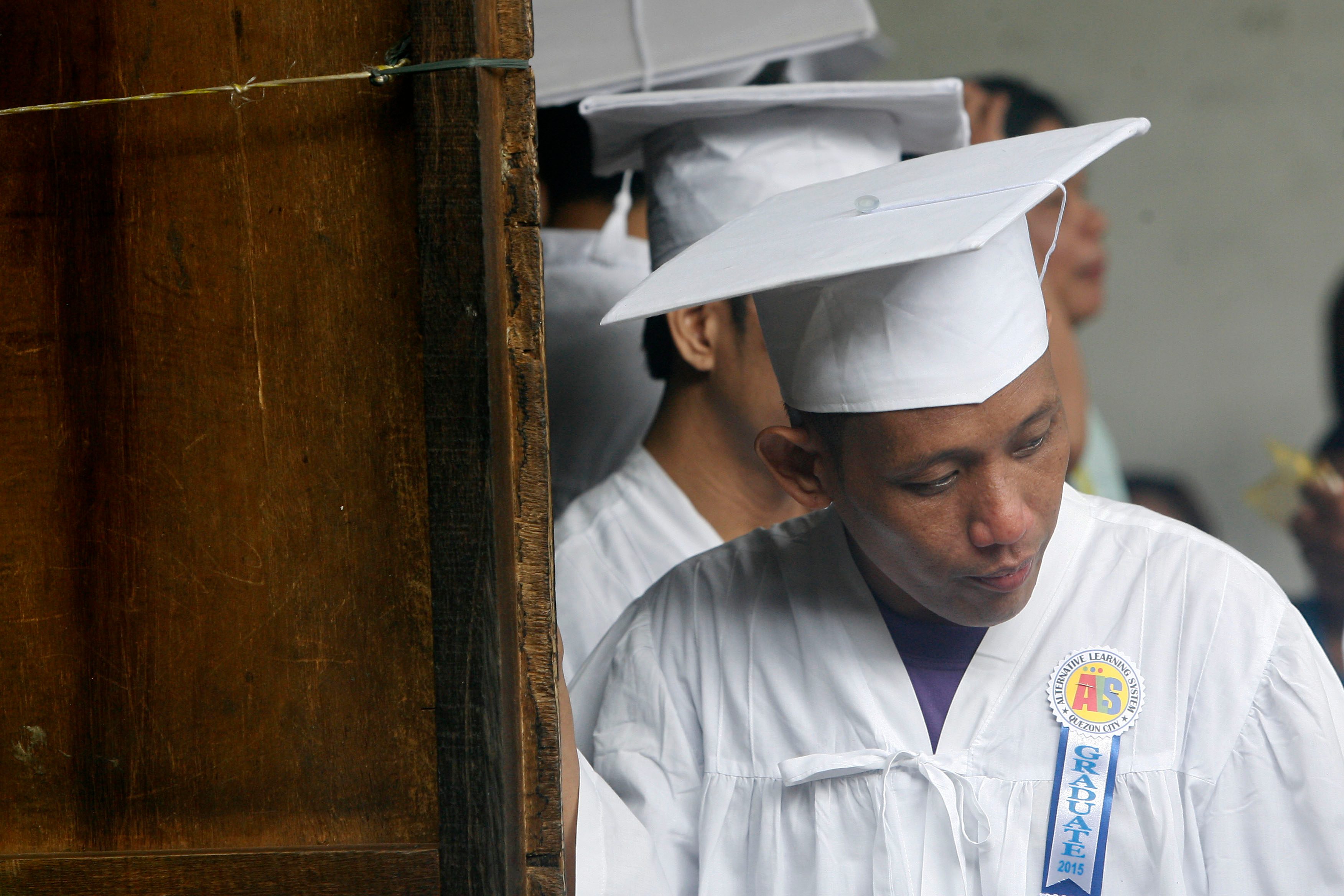 Julius Ceniza stands in front of the line, being the only elementary level graduate in the batch. 