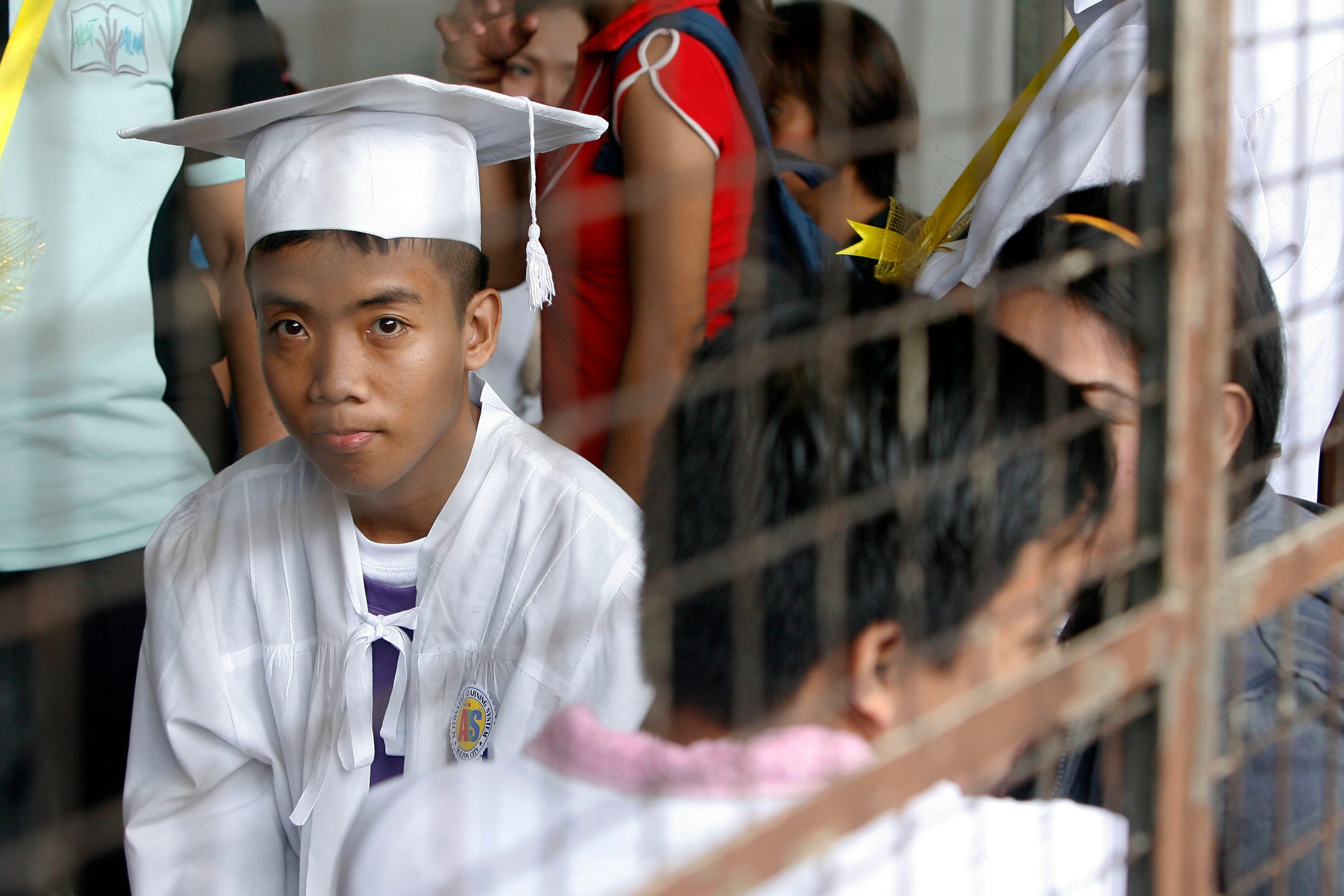Victorio Principe patiently waits for the start of their graduation at the Alternative Learning System (ALS) program of the DepEd. 