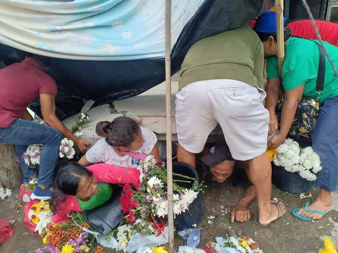 PINNED. Flower vendors at a public market in Padada, Davao del Sur, are trapped underneath a wall. Photo from John Angelo Jomao-as | via PDRRMC DavNor 