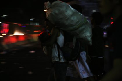 PASAN.  Seorang pria membawa tas perbekalan, tas pakaian dan anaknya dalam pelukannya yang tampak sebagai penitensyanya untuk perayaan Pekan Suci tahun ini.  Foto oleh Emil Sarmiento