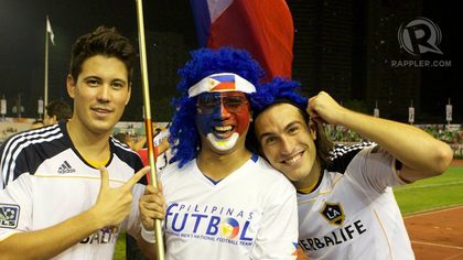 Azkals players and a fan hold the Philippine flag up high after the Dream Cup. December 3, 2011. Rupert Ambil.