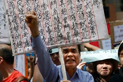 PROTESTS. A demonstrator shouts during a protest to denounce the governments voting system outside the venue where a 1,200-member election committee are to choose the city's new leader, in Hong Kong, on March 25, 2012. The vast majority of Hong Kong's seven million residents have no right to vote in the "small circle" poll, according to the One Country, Two Systems arrangement by which China has ruled the former British colony since 1997. Photo by AFP