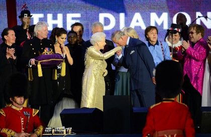 Prince Charles kisses the hand of Britain's Queen Elizabeth II on stage as British singers Paul McCartney (3rdR) and Elton John (R) and other performers look on after the Jubilee concert at Buckingham Palace. in London, on June 4, 20112. A chain of more than 4,200 beacons began to flare across the globe Monday to mark Queen Elizabeth II's diamond jubilee, with the last to be lit by the monarch at a star-studded concert at Buckingham Palace. AFP PHOTO / LEON NEAL