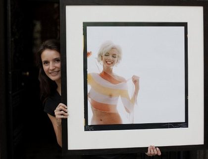 LAST SITTING. A Lyon and Turnbull employee poses with one of the last photographs taken of Marilyn Monroe 'Marilyn Monroe in Stripe Scarf (The Last Sitting)' by Bert Stern during a photocall in central London, on September 29, 2009. AFP PHOTO/Shaun Curry
