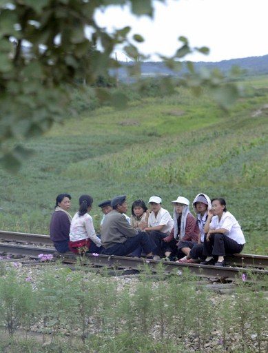 SCENIC? In a picture taken on September 2, 2011 a group of North Korean residents rest along a railway track as they apparently gathered to spruce up the areas along the railway line leading through their town near the special economic zone of Rason in northeast North Korea. Journalists are normally banned from going to the impoverished state, but a select group of reporters was recently invited to join Chinese tour operators on a visit to North Korea aimed at promoting tourism in a remote region. Photo from AFP