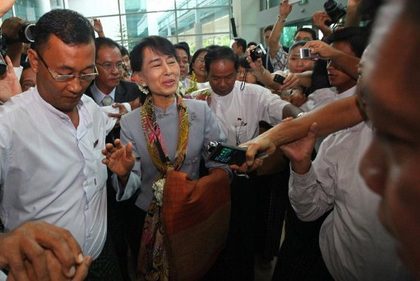 Myanmar opposition leader Aung San Suu Kyi (C) is surrounded by media representatives ahead of her departure at Yangon International Airport on June 13, 2012. Democracy icon Aung San Suu Kyi left Myanmar on June 13 on her first trip to Europe since 1988 to formally accept the Nobel Peace Prize that thrust her into the global limelight two decades ago. AFP PHOTO/Ye Aung Thu