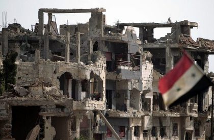 SHAKY CEASEFIRE. A general view shows the Syrian flag flying next to destruction in the Baba Amr neighborhood of Homs on May 2, 2012. The head of the UN mission to Syria said his observers were having a "calming effect" on the ground but admitted the ceasefire was "shaky" and not holding. Photo by Joseph Eid, AFP