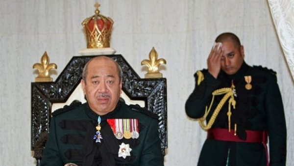 This file photo taken on July 31, 2008 shows Tonga's new monarch, King Siaosi (George) Tupou V, sitting on his throne as aide-de-camp Christian Tupou (R) wipes sweat. Photo from AFP