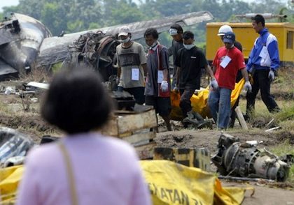 BODY BAGS. Investigators retrieve bodies from the crash site. AFP photo